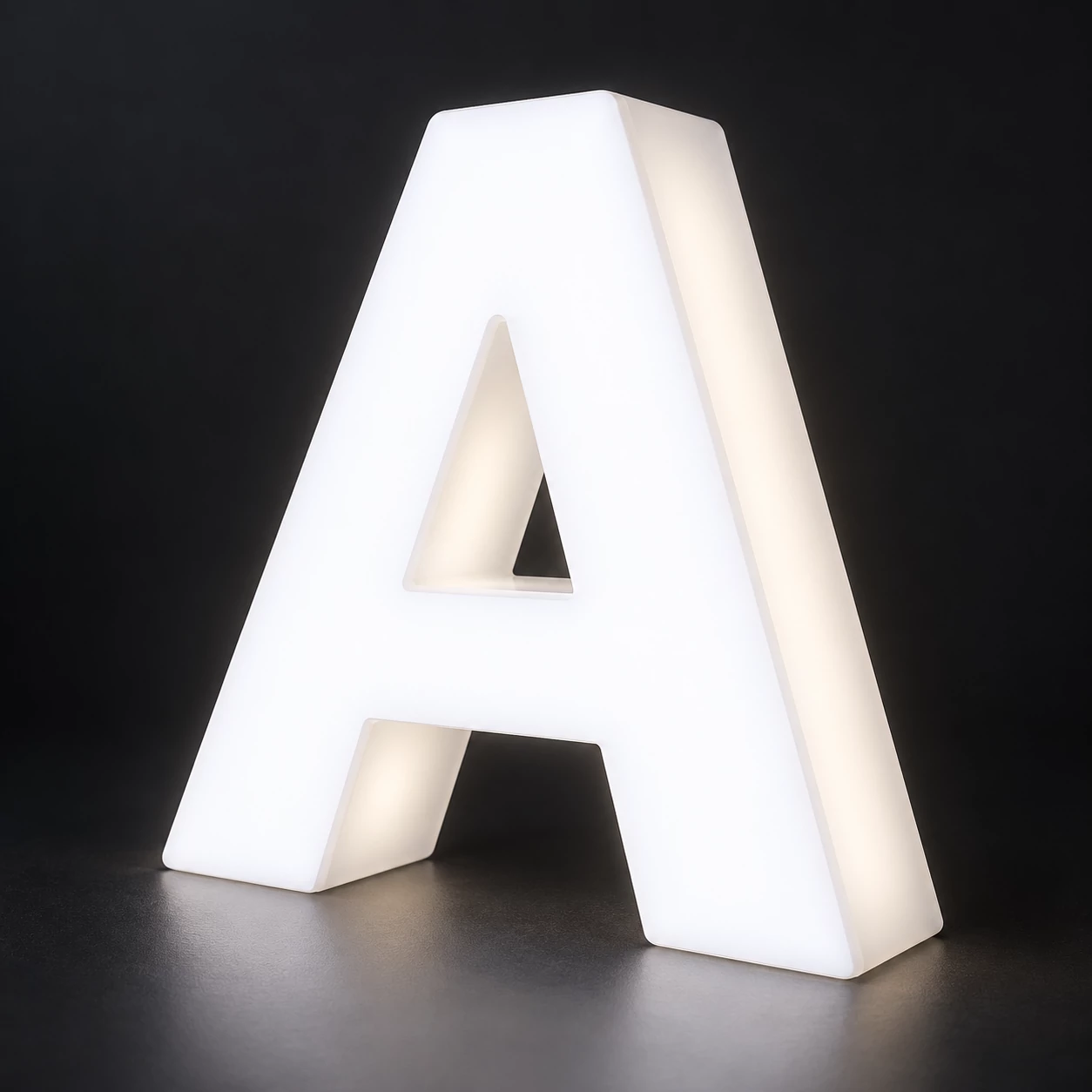 Close angled view of a thick acrylic A with a white illuminated face and frosted glowing side