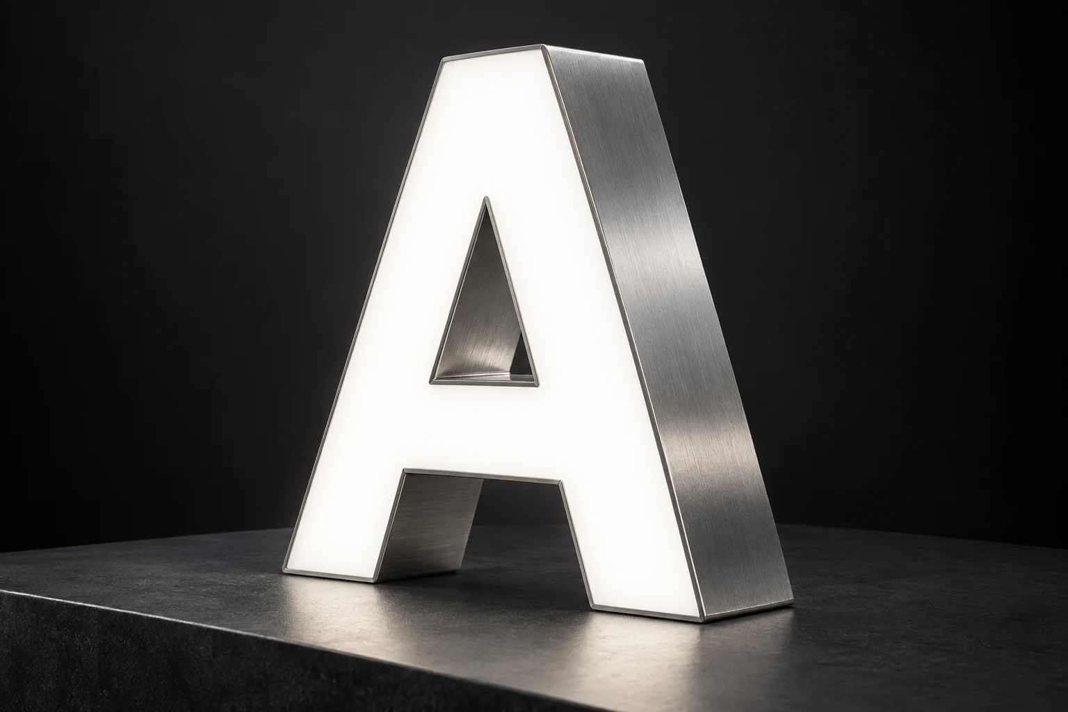 Close view of a channel letter A showing a white acrylic face, brushed metal side return and finished edge