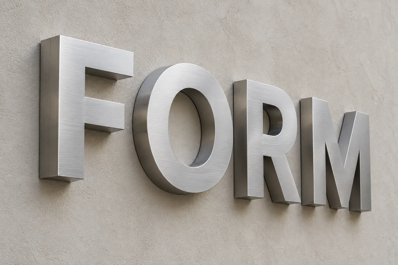 Fabricated brushed silver FORM metal letters showing deep side returns and shadows on a pale wall