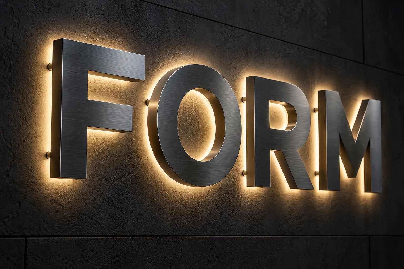 Brushed metal FORM letters with opaque faces and warm white backlighting forming halos on a dark wall