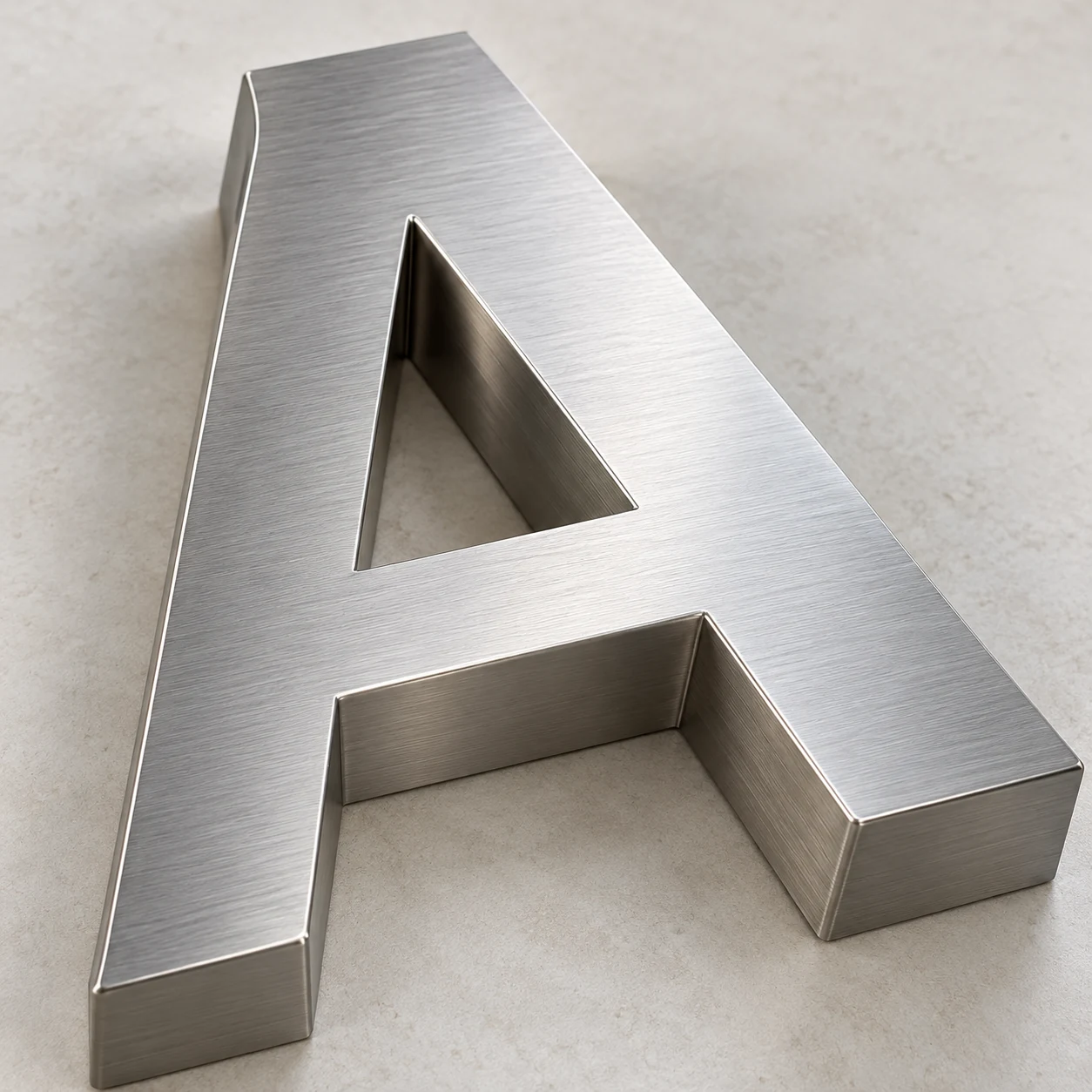 Close view of a brushed silver metal A showing the finished face, edge and deep side return