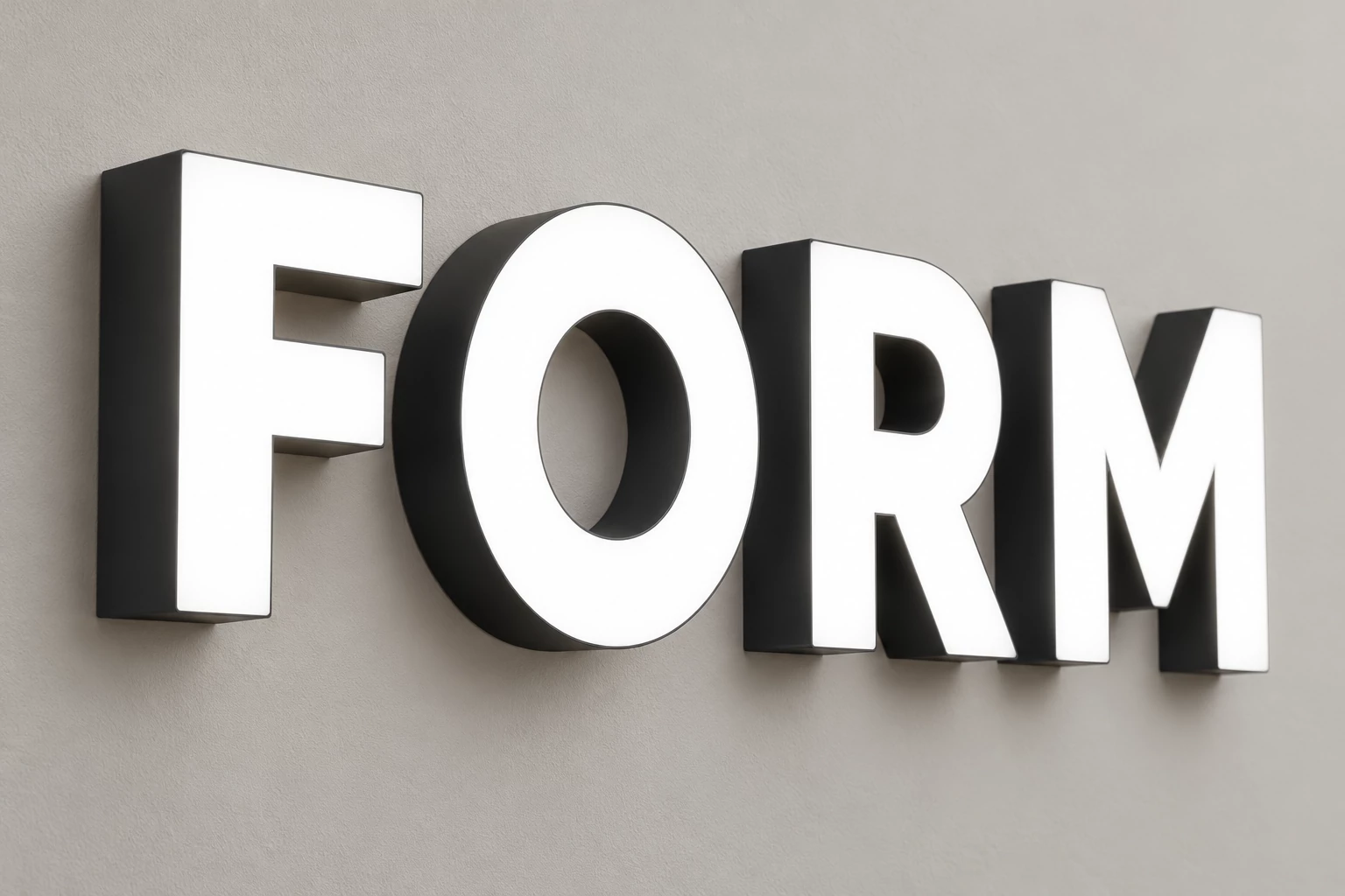 Compact FORM acrylic LED letters with white illuminated faces and dark sides on a pale wall