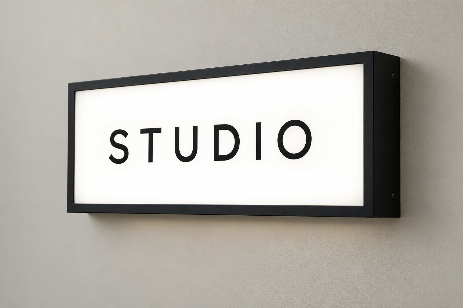 Rectangular wall-mounted STUDIO lightbox with an illuminated white face and a matte black frame